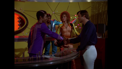 Buck Rogers in the 25th Century's "Space Rockers" aired this day, 21 February, in 1980 CE. Seen here is William "Buck" Rogers who meets with three of the musicians who comprise the band Andromeda in their recording studio aboard Music World (BR25: "Space Rockers").