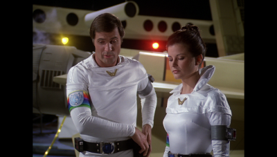 Capt. William "Buck" Rogers and Maj. Marla Landers are given specialized equipment by Twiki and Dr. Theopolis before their departure for Sinaloa (BR25: "Vegas in Space").