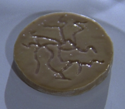 A food disc from Vistula undergoing testing by Dr. Mallory (BR25: "Planet of the Slave Girls").