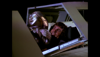 William "Buck" Rogers, Twiki and Dr. Theopolis cram into the back seat of Wilma Deering's Thunderfighter, making their escape from Draconia before its destruction (BR25: Film, "Awakening").