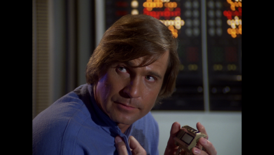 William "Buck" Rogers with a wrist imager removed from a Saurian infiltrator aboard Searcher (BR25: "Mark of the Saurian").