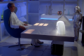 [Photo 4]: After a subspace conversation with Maj. Duke Danton, Dr. Elias Huer sits at his desk, and one can see that his chair is held into place by two wood wedges and a mess of wires coming out from under the desk as the camera pans out (BR25: "Planet of the Slave Girls").]]